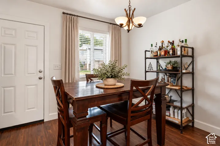 Wood-finish flooring, white paneled door, window with blinds, and a built-in shelving unit digital staging pieces