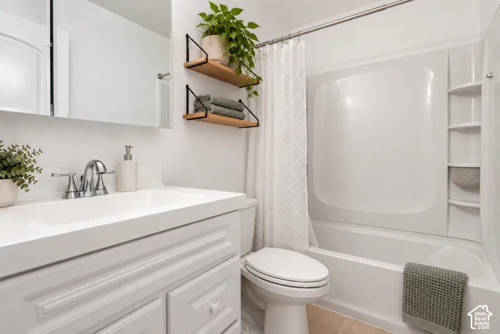 White vanity with integrated sink, chrome faucet, wall-mounted mirror, built-in tub with shower, and integrated shelvingDigitally staged