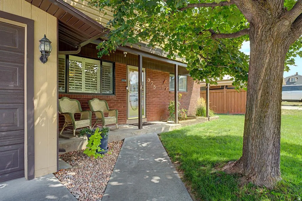 Brick facade with a covered porch, an attached garage, and a concrete walkway