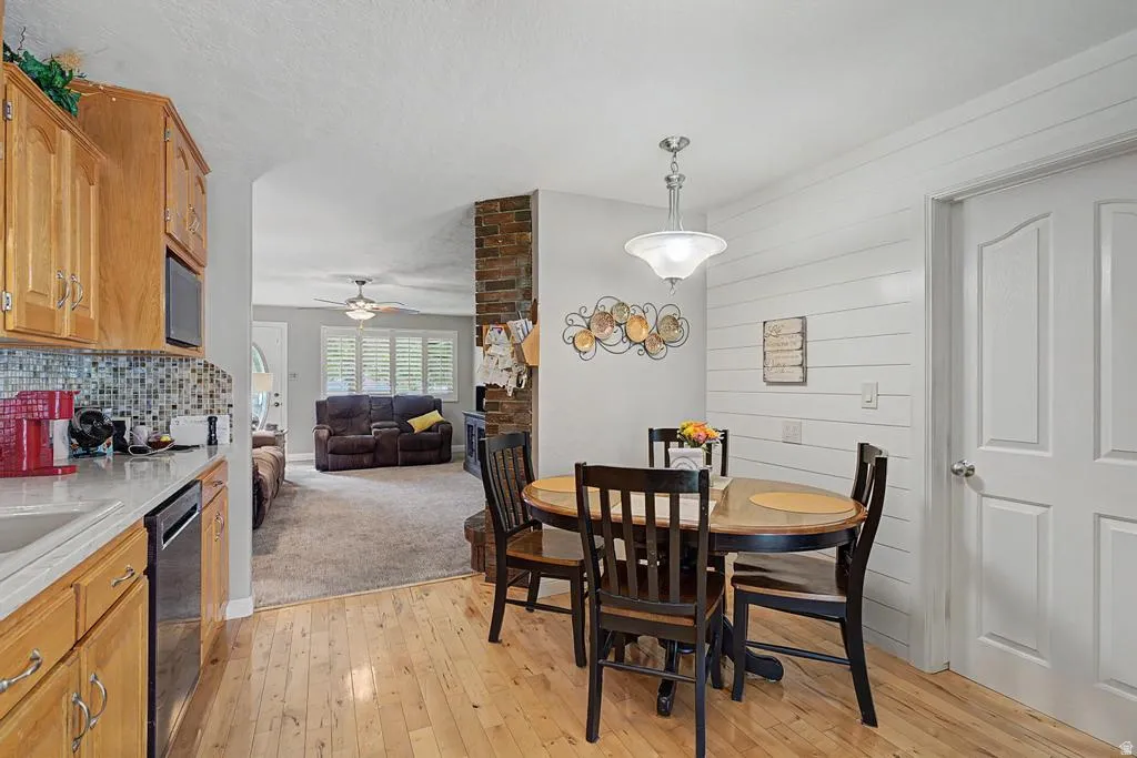 Kitchen featuring wood-finish flooring, light wood cabinetry, and a mosaic tile backsplash