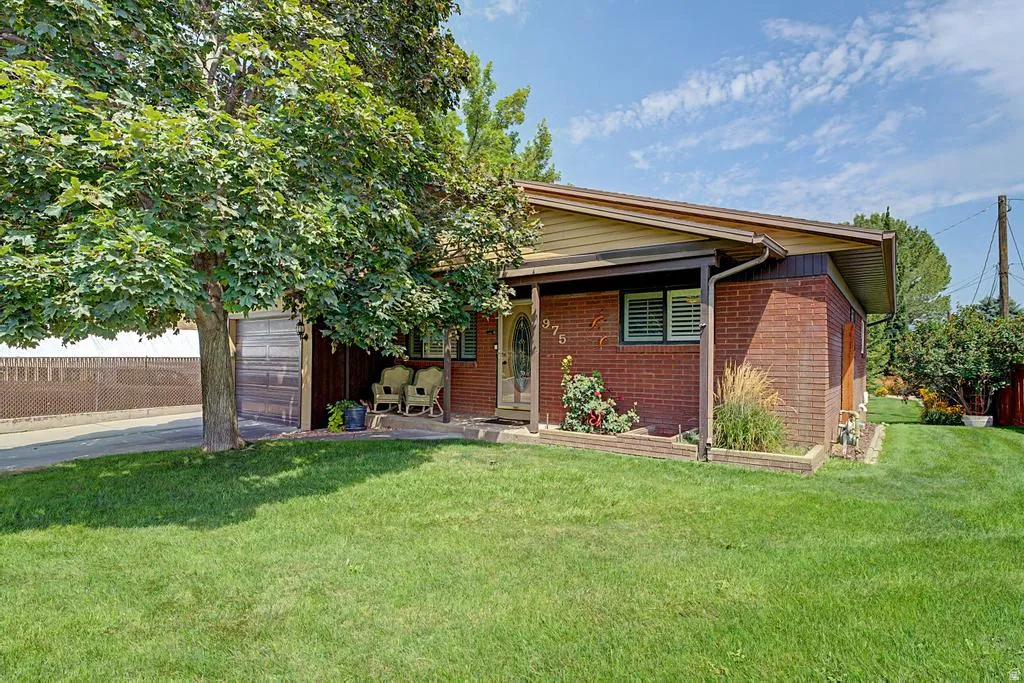 Brick exterior home with a partial front porch and an attached garage