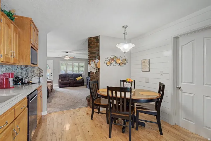 Kitchen featuring wood-finish flooring, light wood cabinetry, and a mosaic tile backsplash