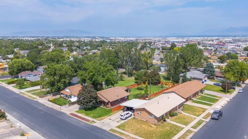 Aerial perspective of a neighborhood with residential structures and mature trees