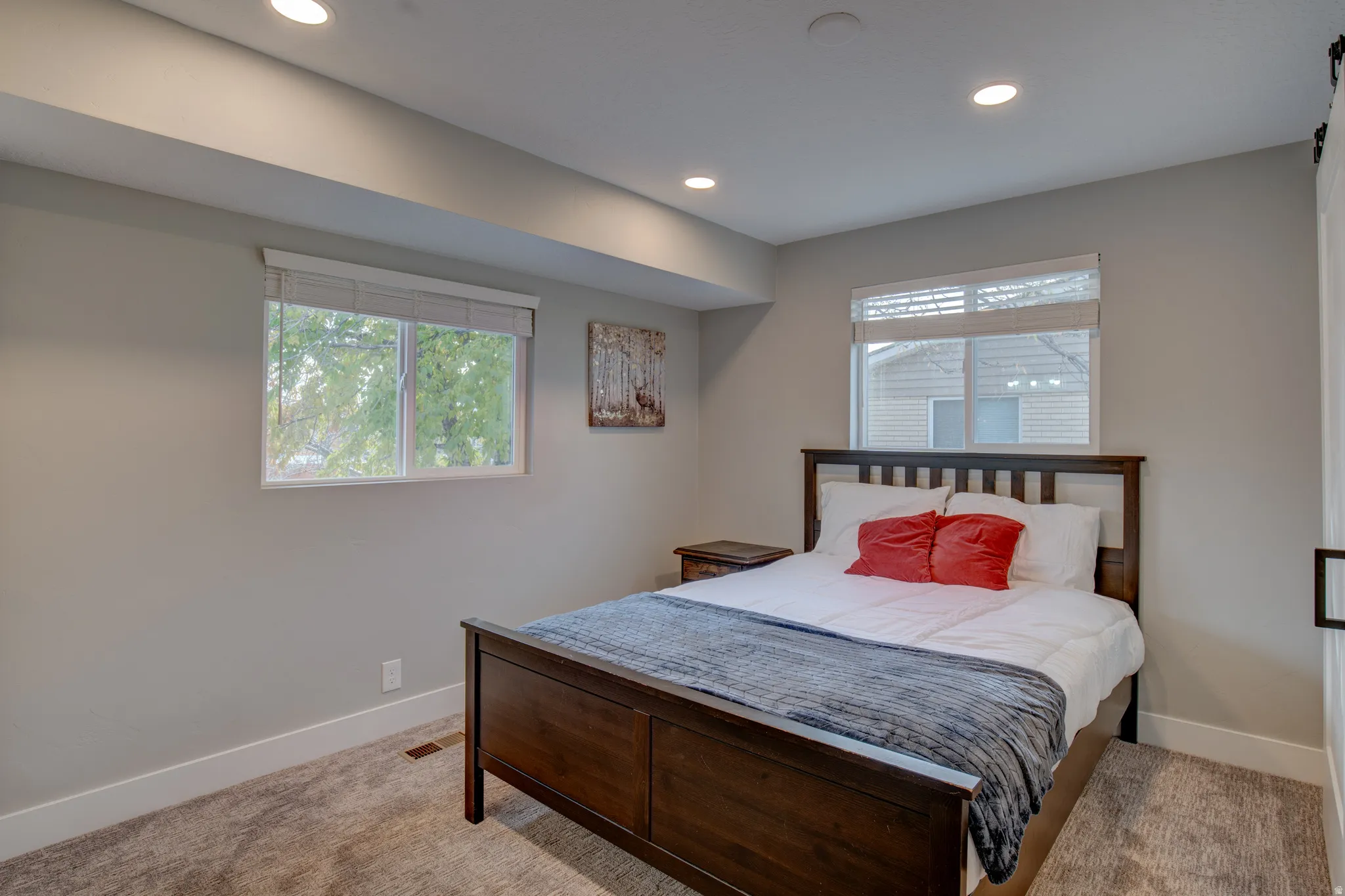 Recessed lighting, light gray wall color, dual windows, and carpeted flooring