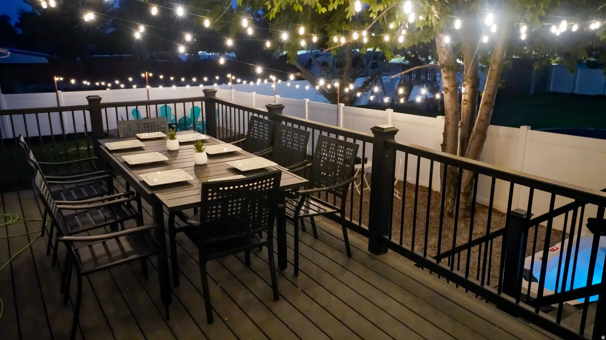 Expansive deck featuring composite decking, dark railings, and a privacy fence