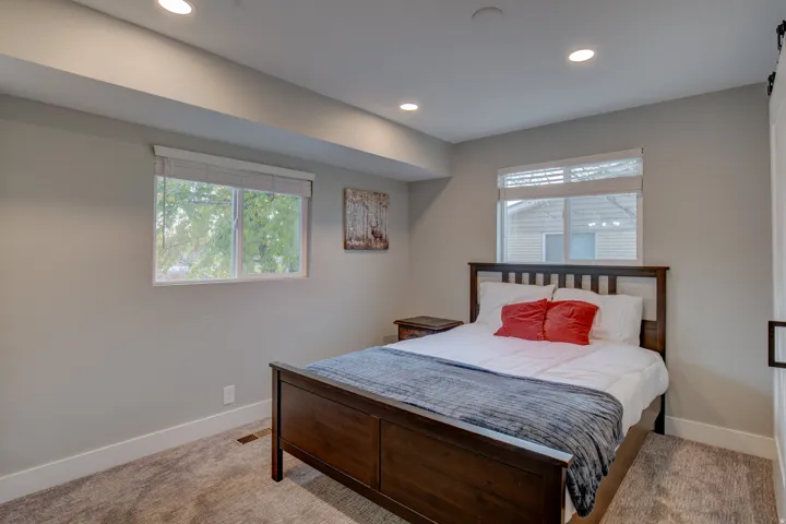 Recessed lighting, light gray wall color, dual windows, and carpeted flooring