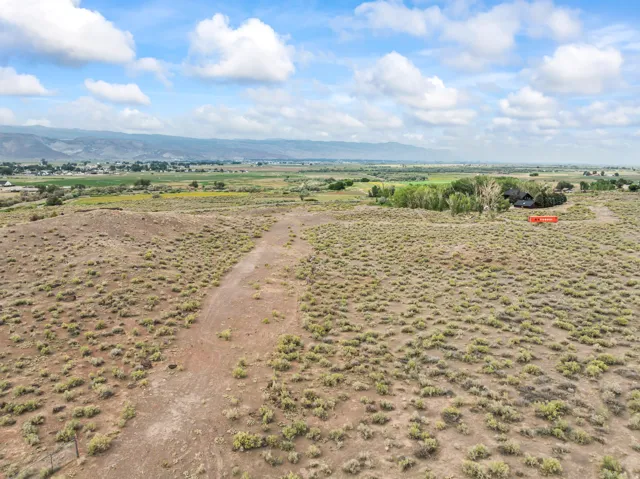 Expansive rural property with natural vegetation and a distant single-family residence