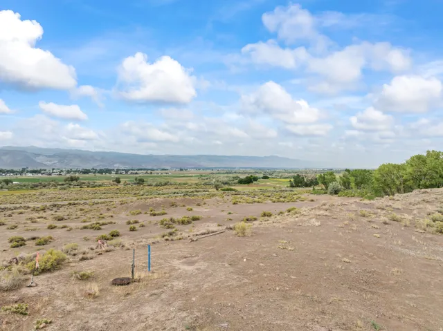 Expansive land offering broad vistas, featuring established natural vegetation and distant mountainous terrain