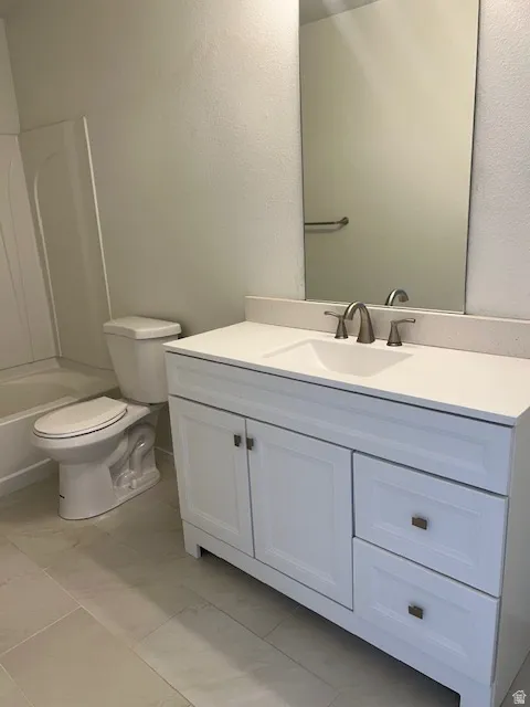 White vanity with shaker-style cabinetry, a white countertop, and an undermount sink