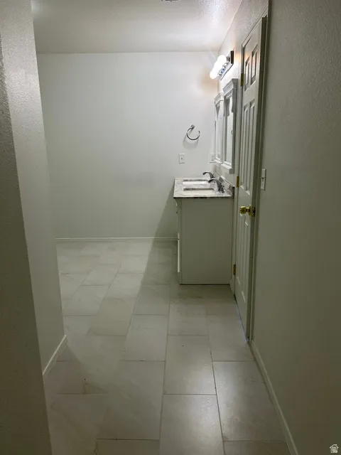 Dual vanity with a stone-finish countertop, undermount sinks, and wall-mounted lighting