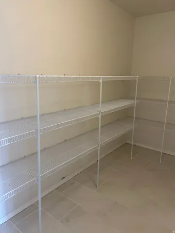 Extensive wire shelving system, light-colored walls, and tile flooring