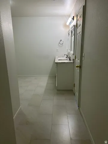 Dual vanity with a stone-finish countertop, undermount sinks, and wall-mounted lighting
