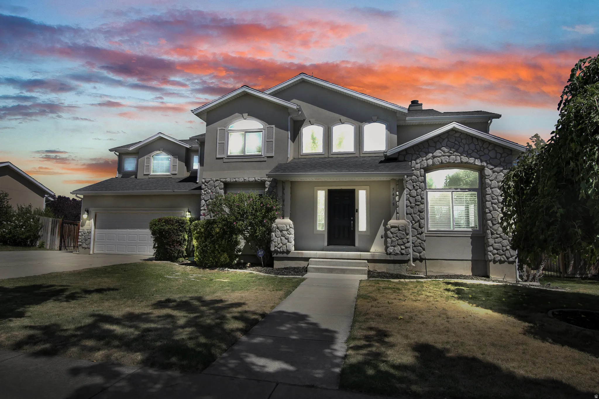 Stucco exterior with stone accents, arched windows, and a prominent front entry with sidelights