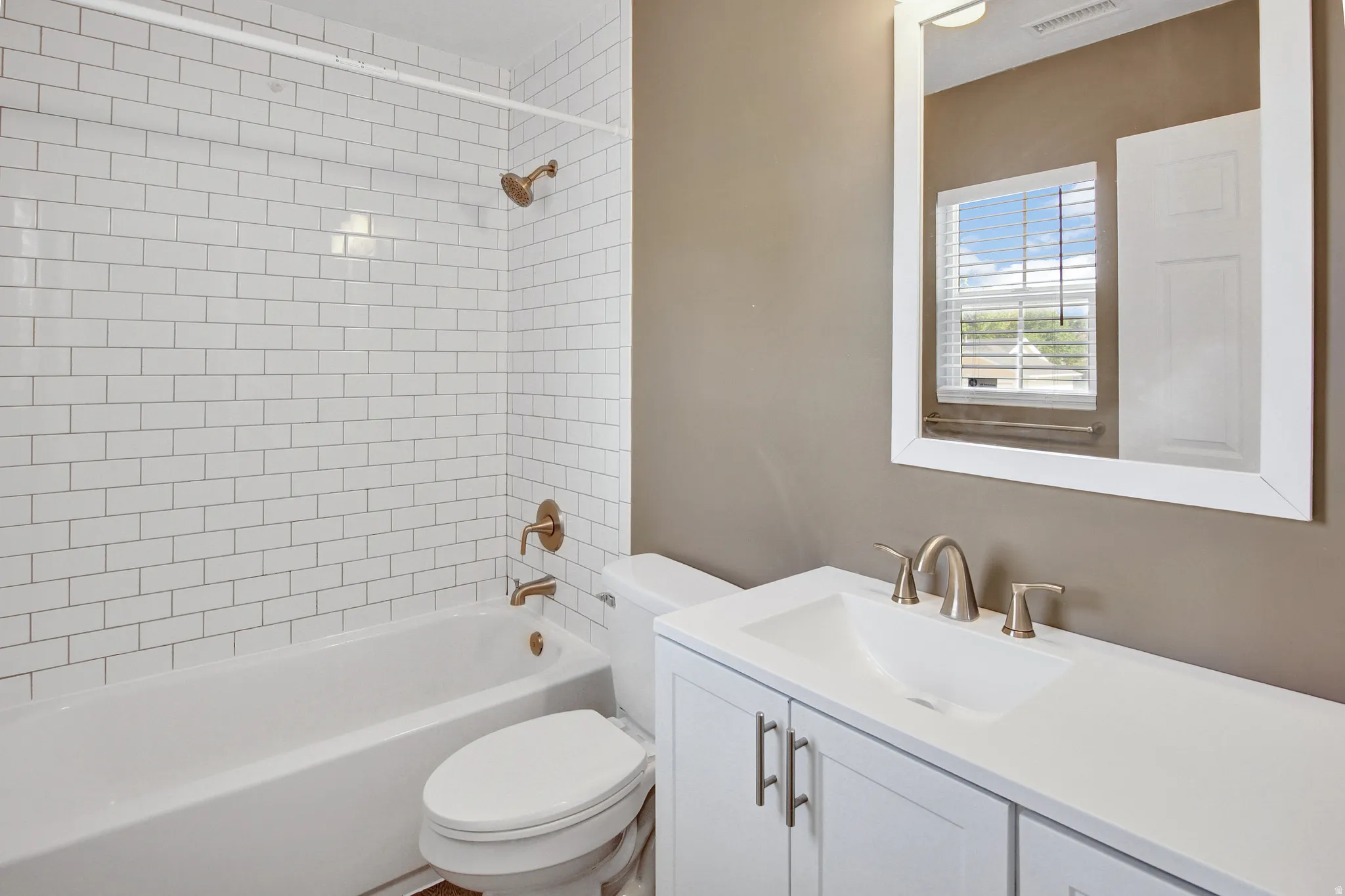 White subway tile shower surround with bronze fixtures