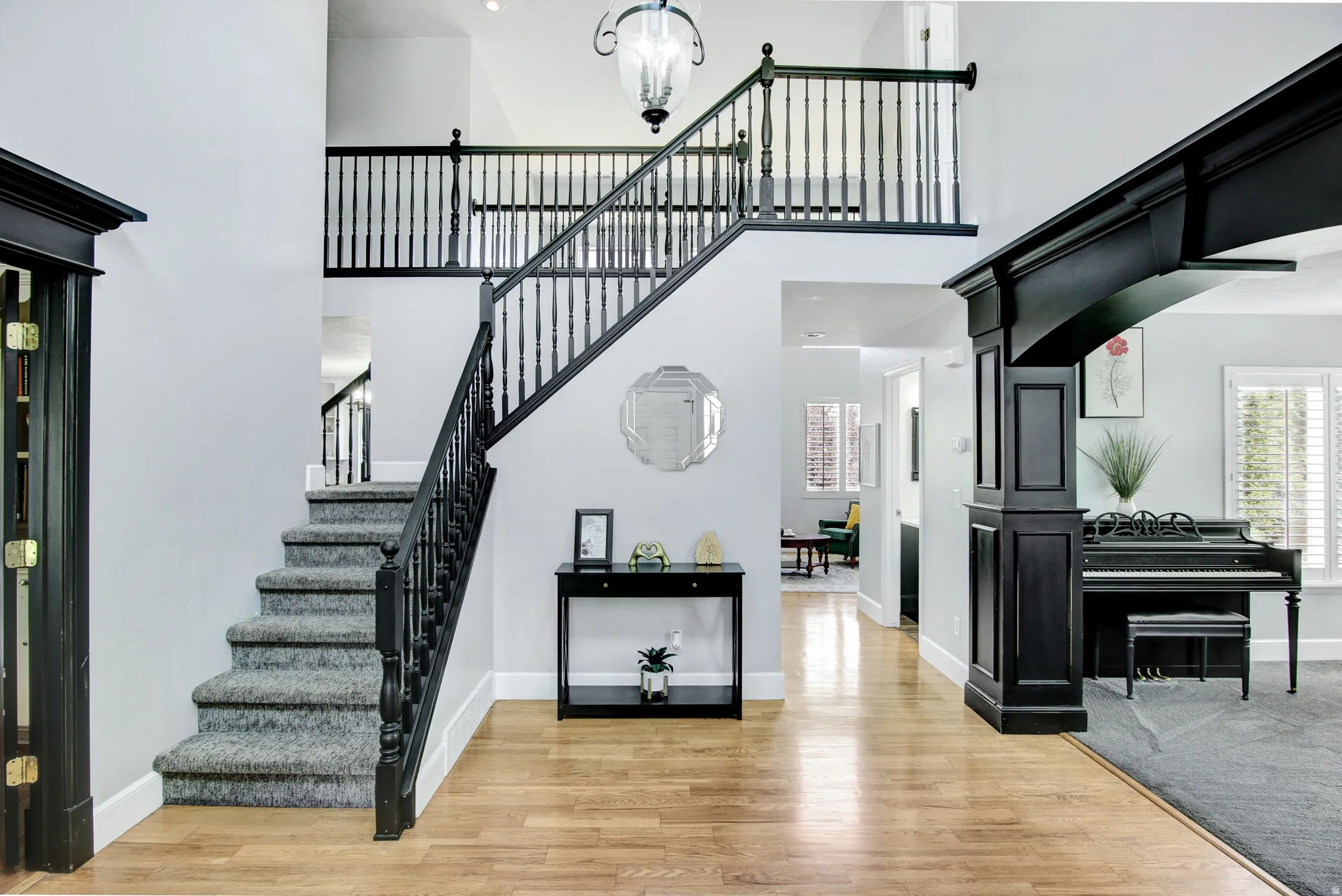 Two-story foyer featuring hardwood-finish flooring and a carpeted staircase