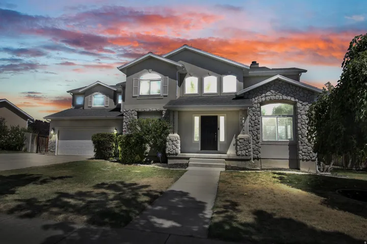 Stucco exterior with stone accents, arched windows, and a prominent front entry with sidelights