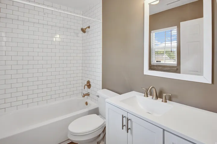 White subway tile shower surround with bronze fixtures