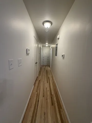 Hardwood flooring throughout, recessed lighting, built-in storage drawers, and white painted walls