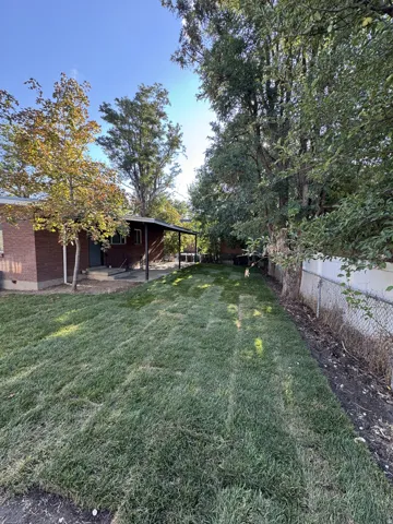 Expansive green lawn with mature trees provide a private shaded backyard.