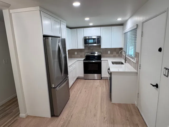 Brand New stainless steel appliances, quartz countertops, and a tiled backsplash