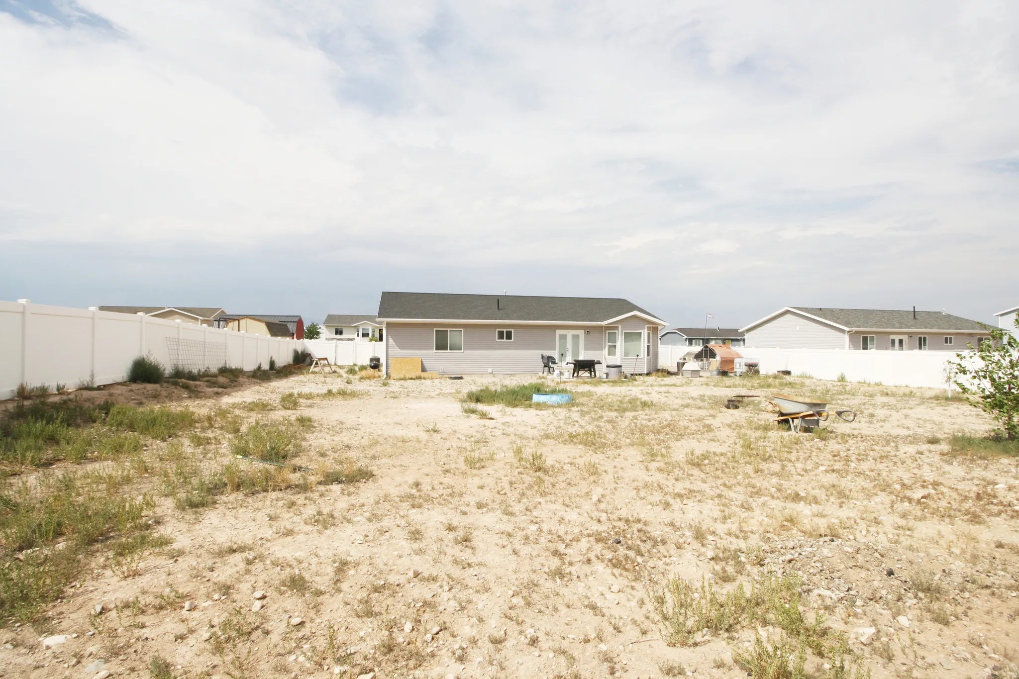 Expansive rear yard with a perimeter privacy fence and a rear patio door