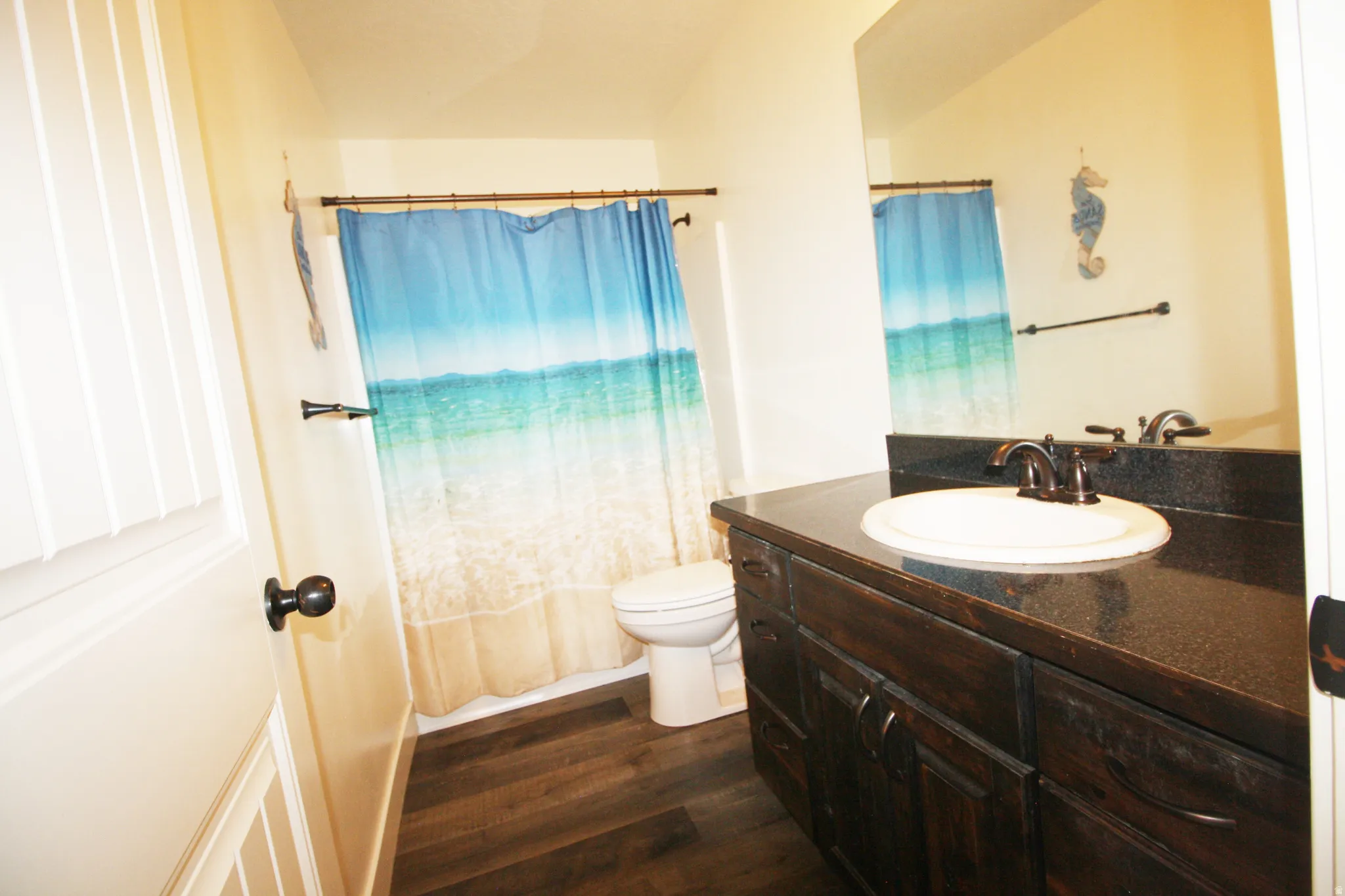 Dark wood-finish vanity with an integrated sink and dark countertop