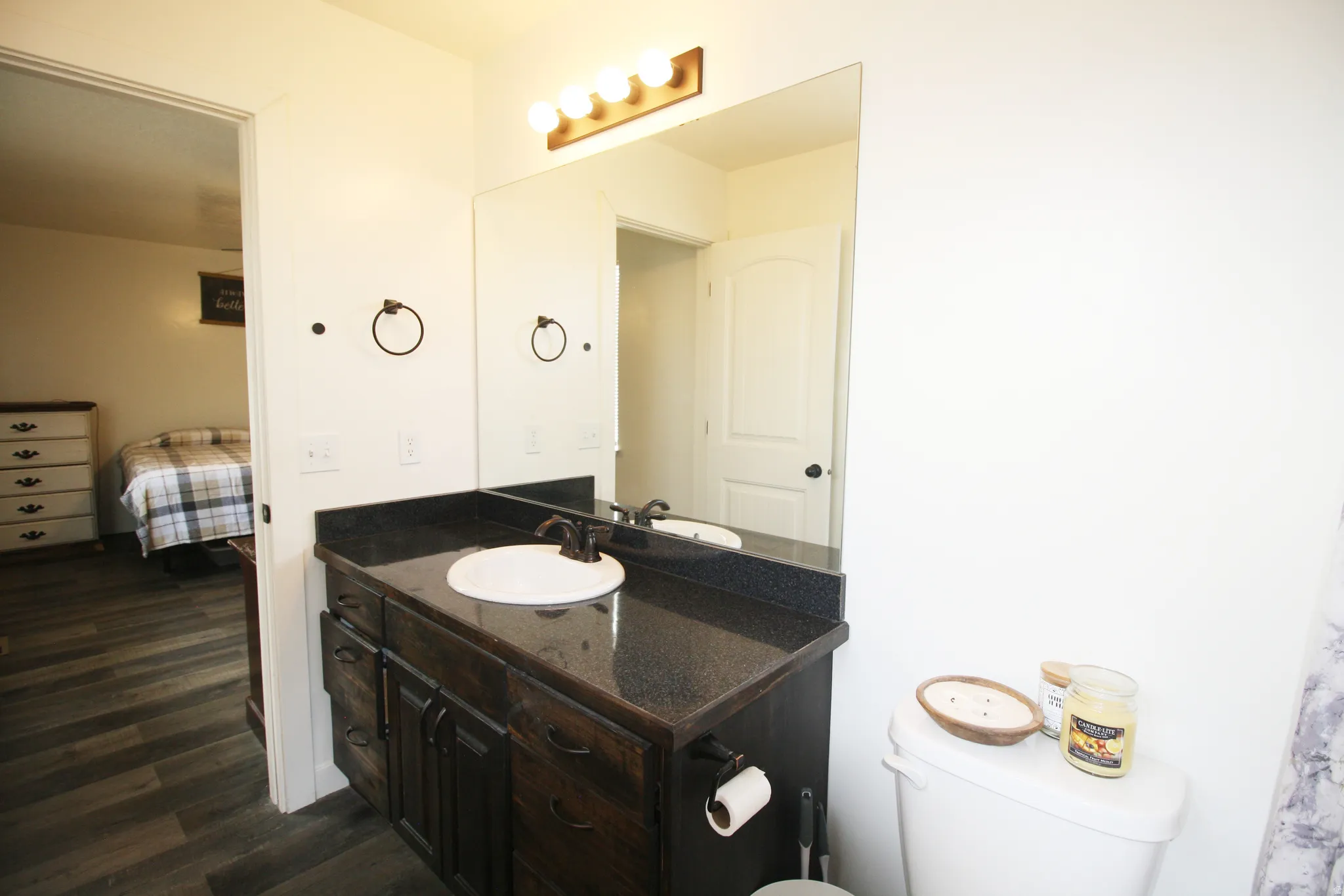 Vanity with a surface-mounted sink, dark cabinetry, and bronze-finish faucet