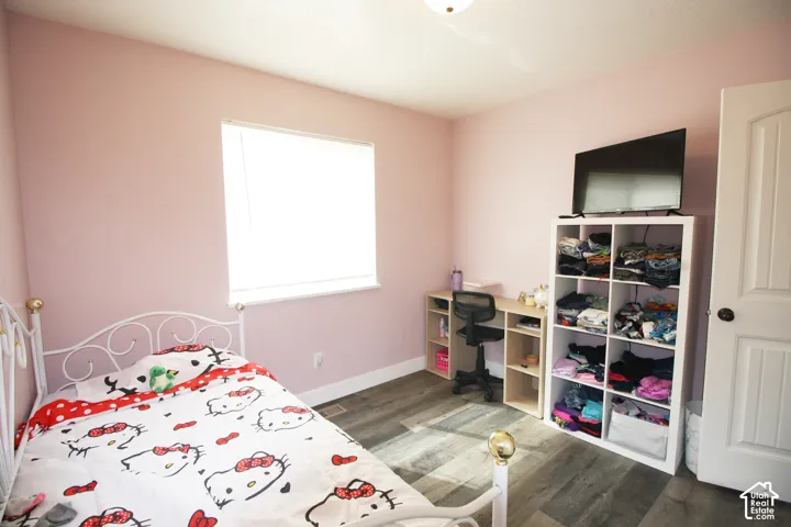 Neutral wall color, wood-finish flooring, and a single window with blinds
