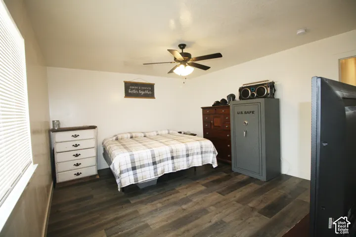 Wood-finish flooring with white walls and a ceiling fan