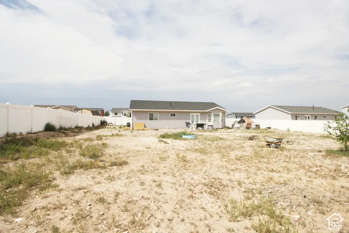 Expansive rear yard with a perimeter privacy fence and a rear patio door