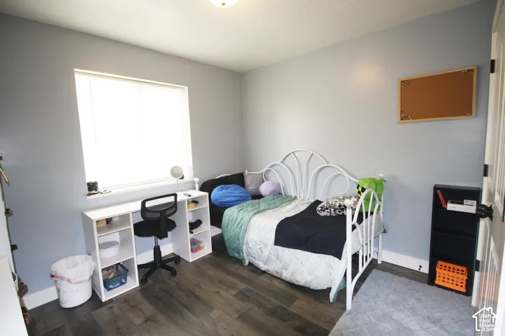 Window with a white frame, wood-finish flooring, and light blue wall color