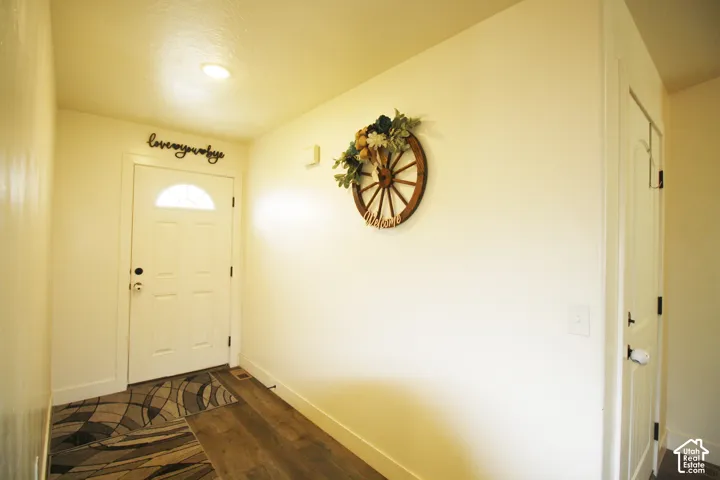 Entryway featuring a white paneled door with an arched glass insert, recessed ceiling lighting, and wood-finish flooring