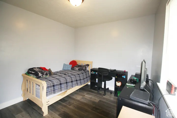 Wall-mounted light fixture, wood-finish flooring, and a window providing natural illumination