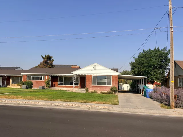 Brick exterior with white trim, a covered carport, and a concrete driveway