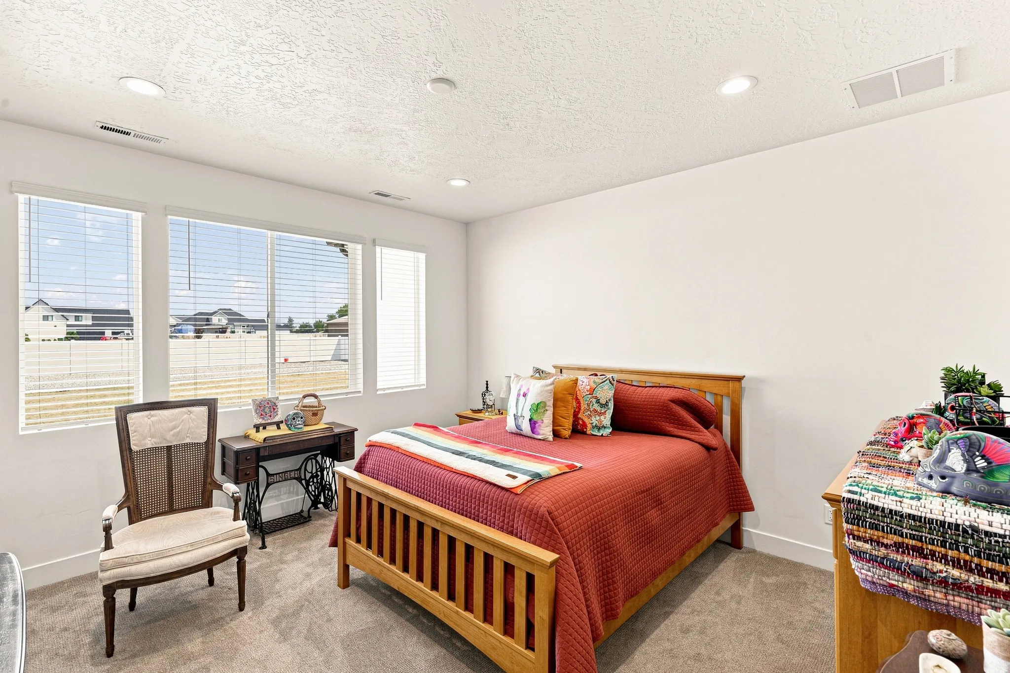 Recessed ceiling lighting, multiple large windows, and neutral carpeting