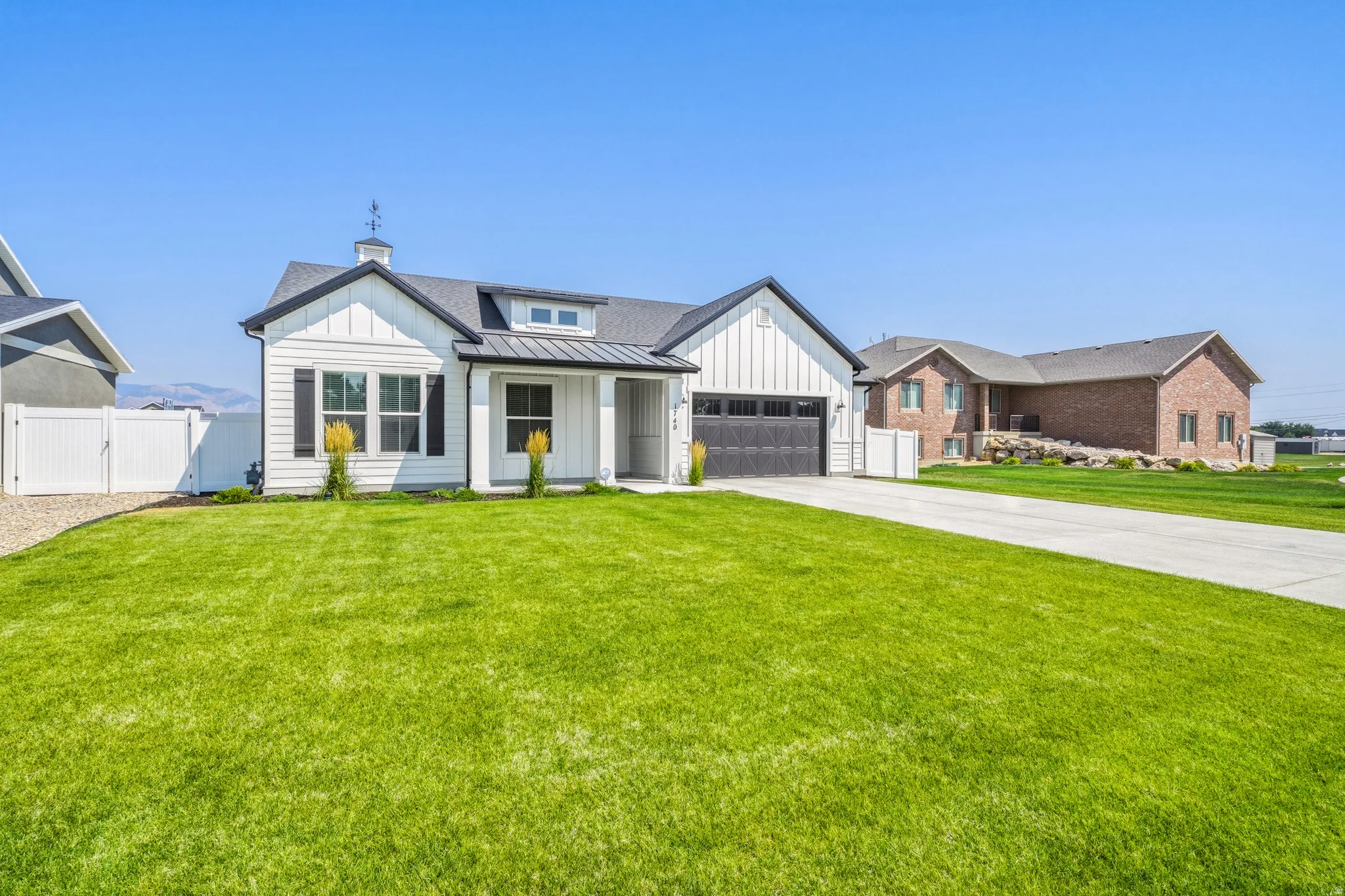 Modern farmhouse exterior featuring a clean-lined facade with board-and-batten siding, multiple gabled rooflines with architectural detail, and a two-car garage
