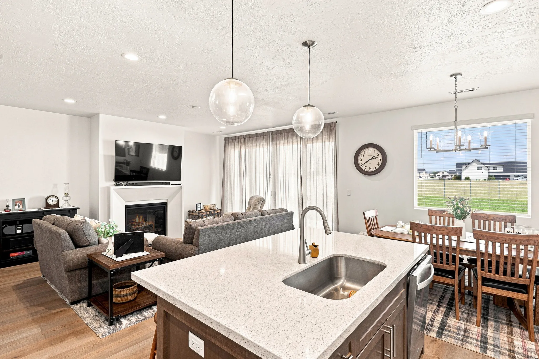 Kitchen island with an undermount sink, a gooseneck faucet, and pendant lighting