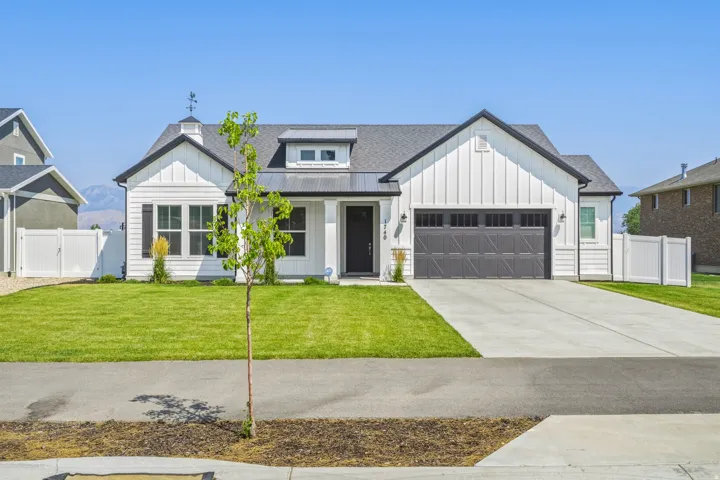 Modern farmhouse exterior with white vertical siding, black trim, and a dark shingle roof