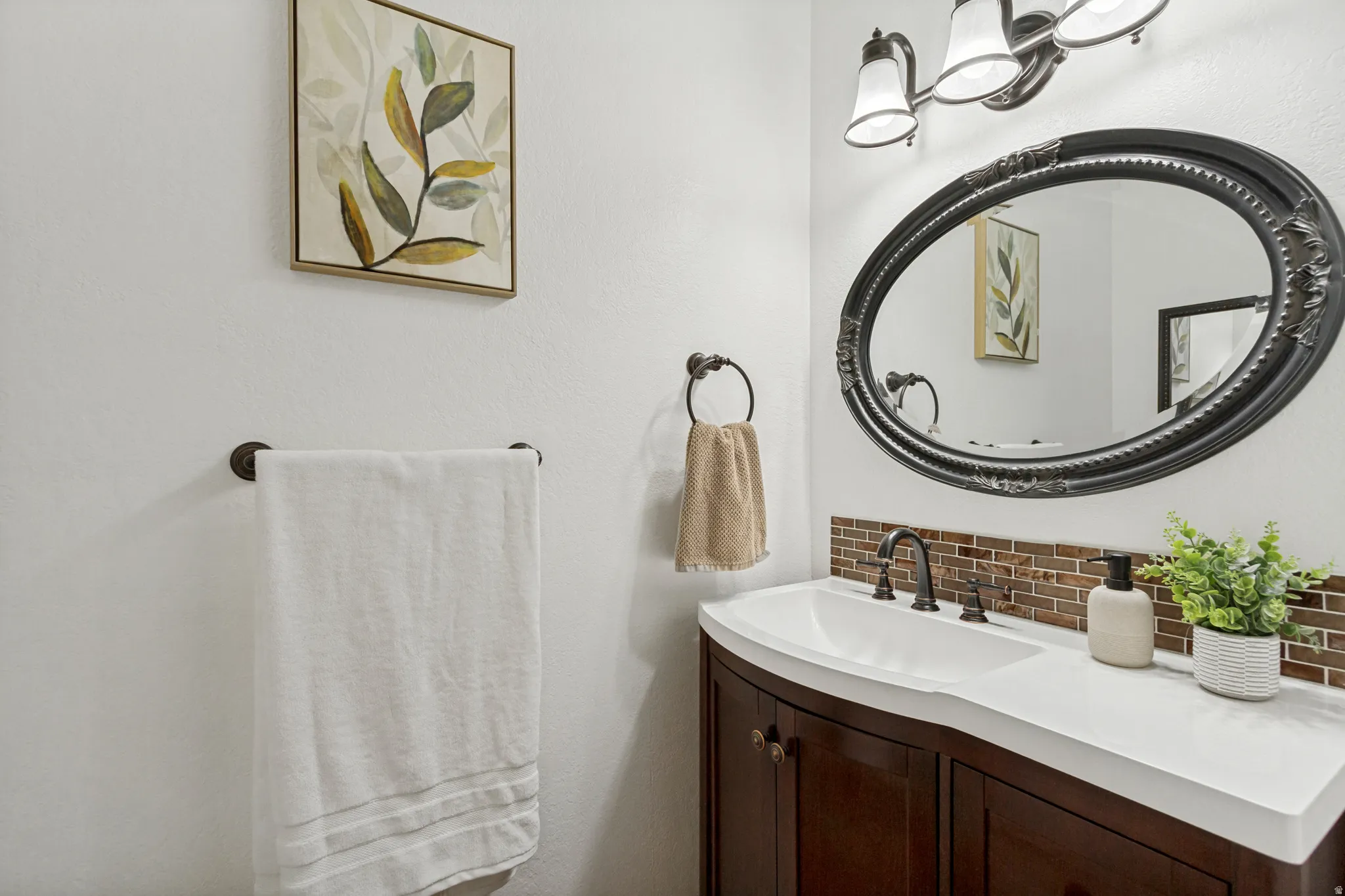 Elegant powder room featuring a dark wood vanity with white countertop, vessel sink, and matte black faucet, white toilet