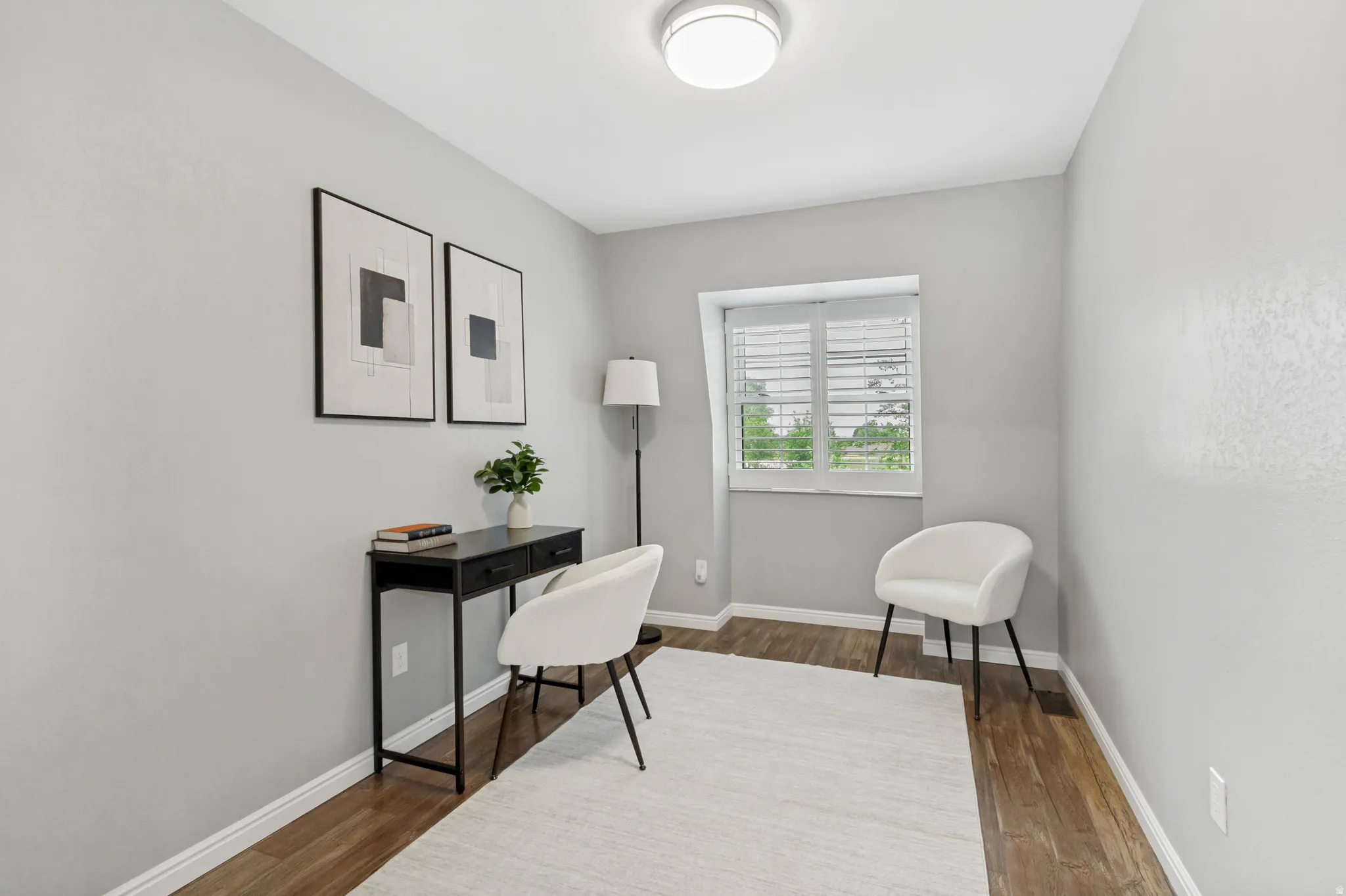 Recessed window with white blinds, wood-finish flooring, light gray wall finishes, and a flush-mount ceiling light fixture