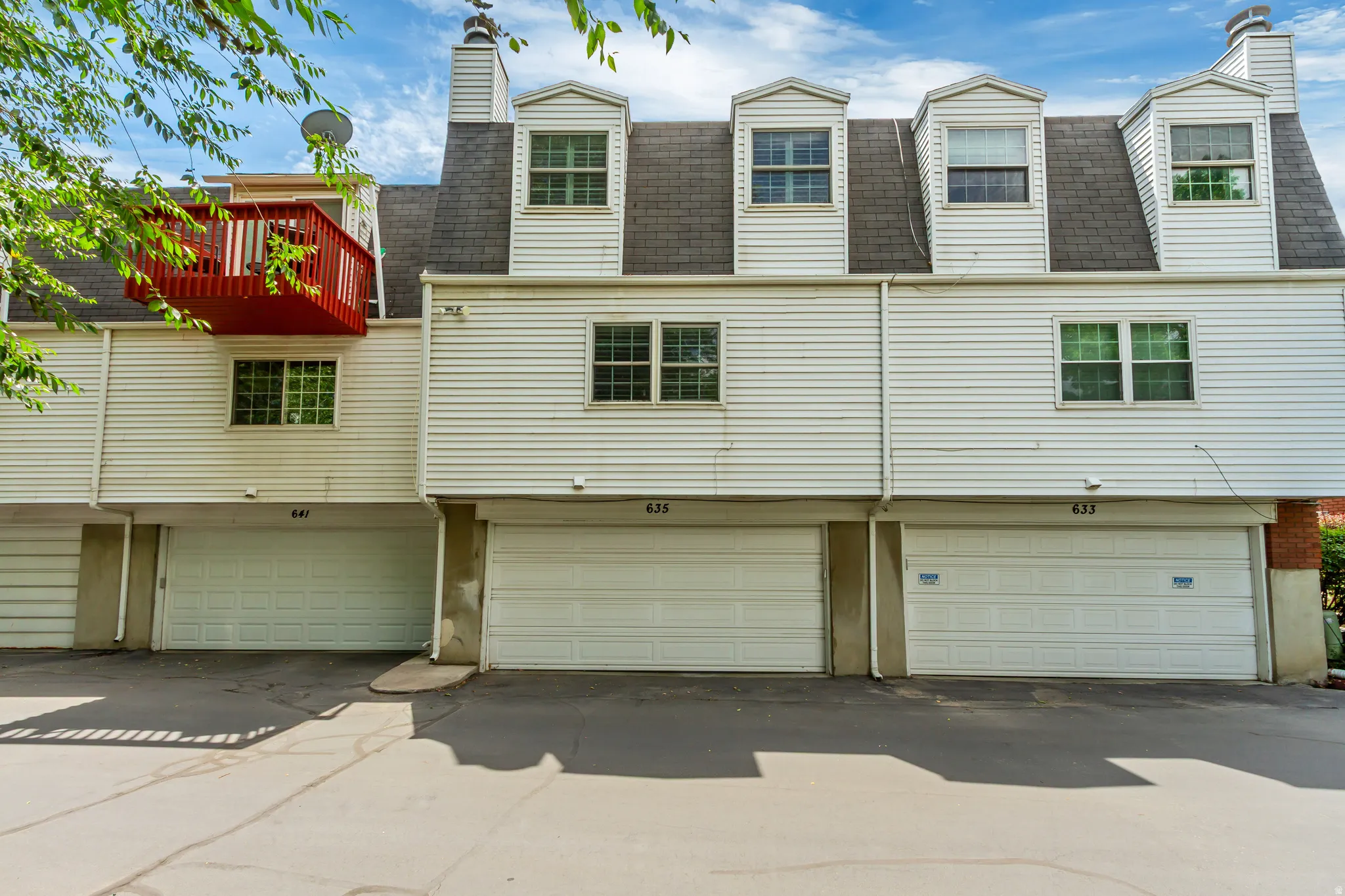 White horizontal siding exterior with a dark shingle roof, multiple dormer windows