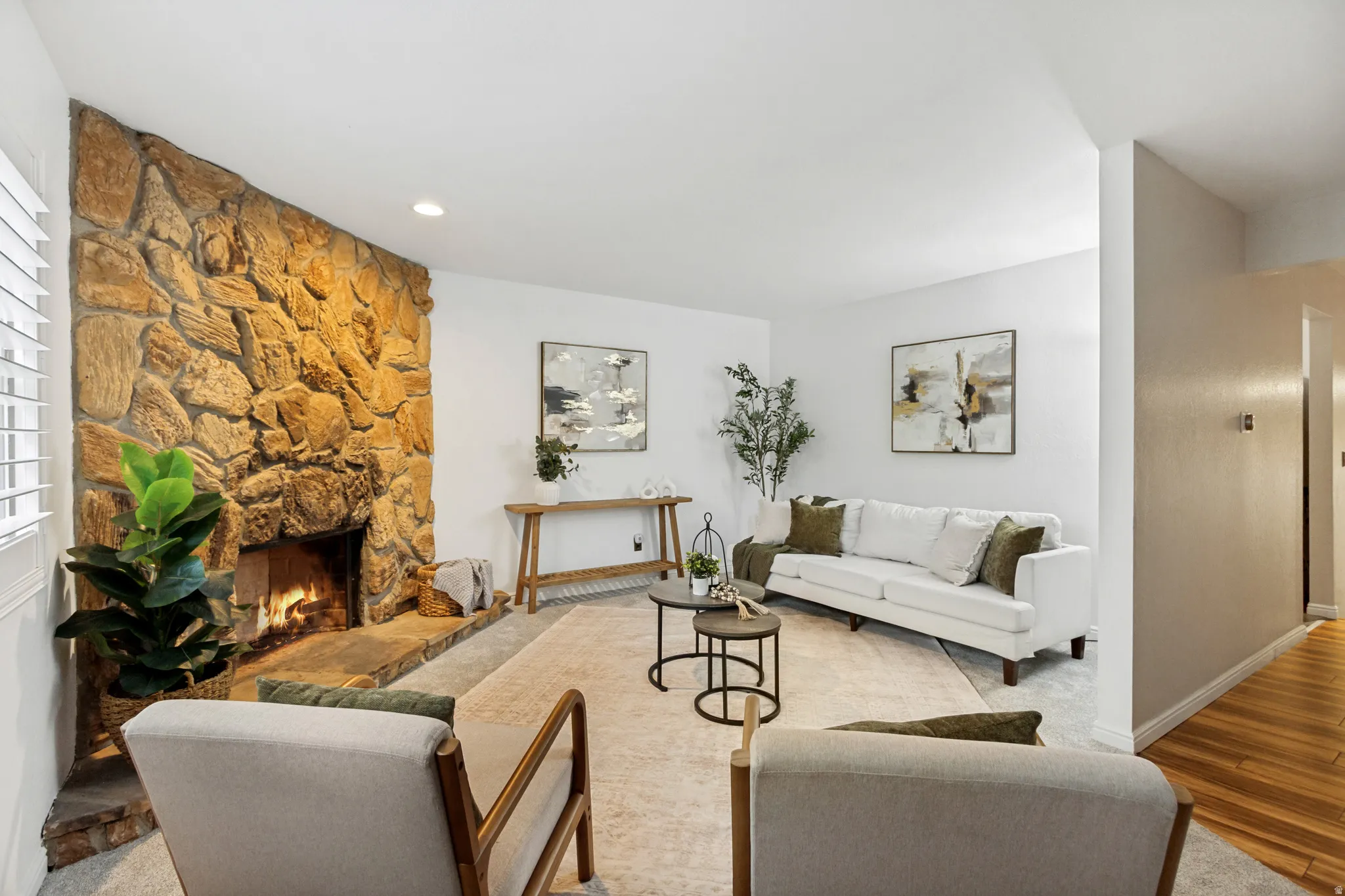 Living area featuring a stone-clad fireplace, light neutral wall paint, recessed lighting, Plantation Shutters