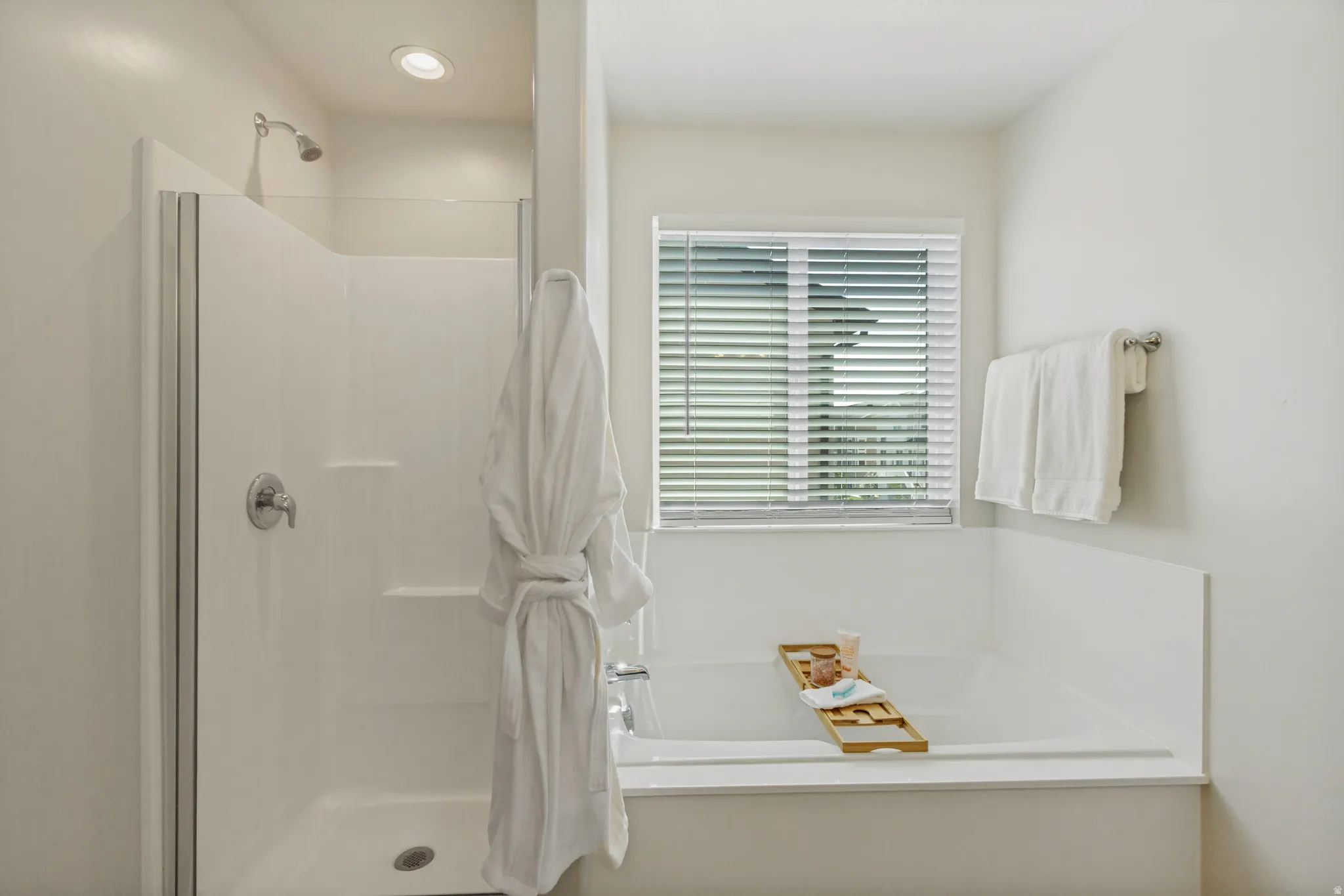Integrated shower and bathtub combination with a window featuring blinds