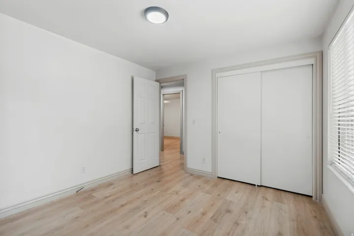 Wood-finish flooring, white walls, and a ceiling-mounted light fixture