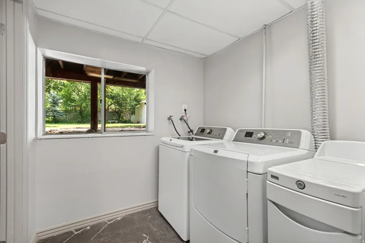 Utility space featuring a drop ceiling, a single window, and a concrete-finish floor