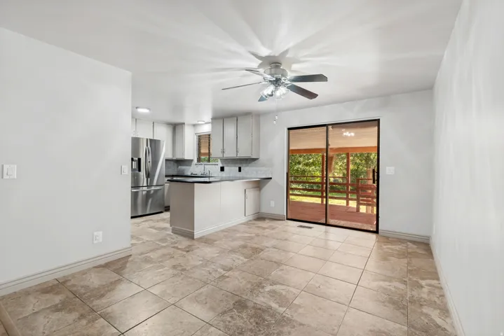 Ceramic tile flooring, white walls, and a ceiling fan