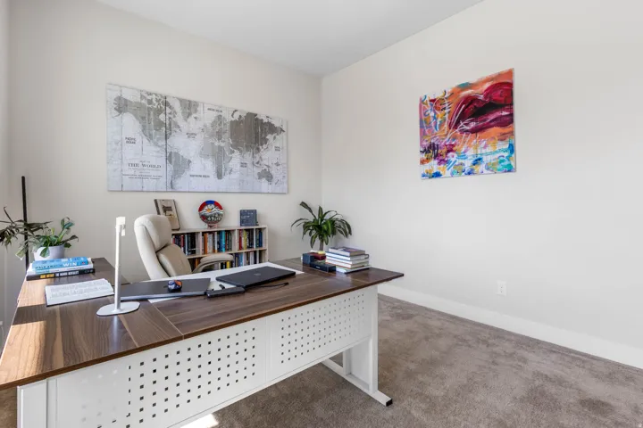 Neutral wall color, wall-to-wall carpeting, and a built-in bookshelf