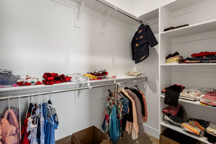 Custom closet system with multiple shelving units and hanging rods