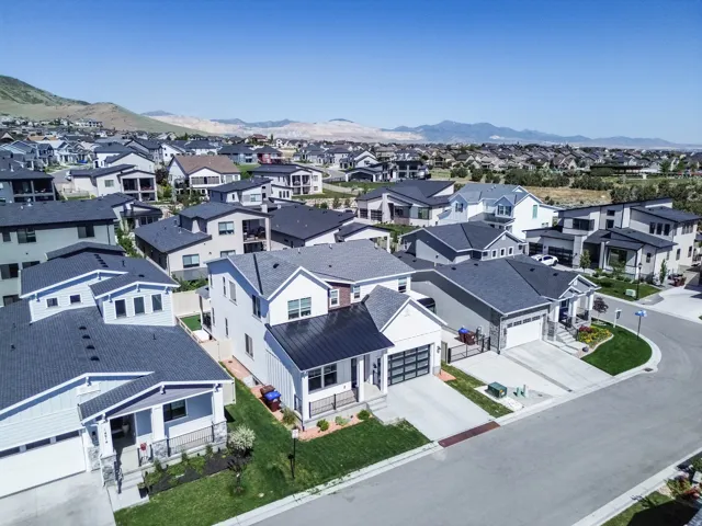 Modern residential neighborhood with varied architectural styles, a street network, and mountainous background scenery
