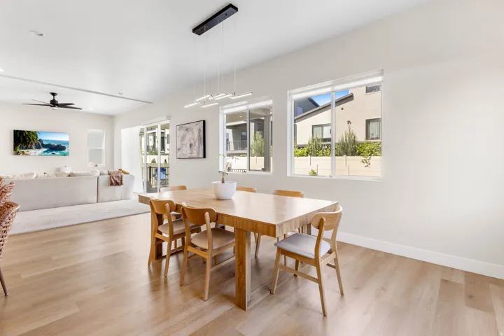 Light wood-finish flooring throughout, bright white walls, and recessed lighting